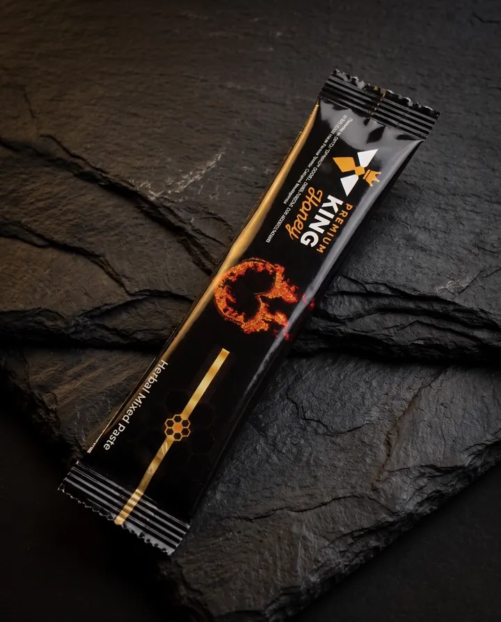 Një bustinë e zezë Premium King Honey mbi rrasë guri.